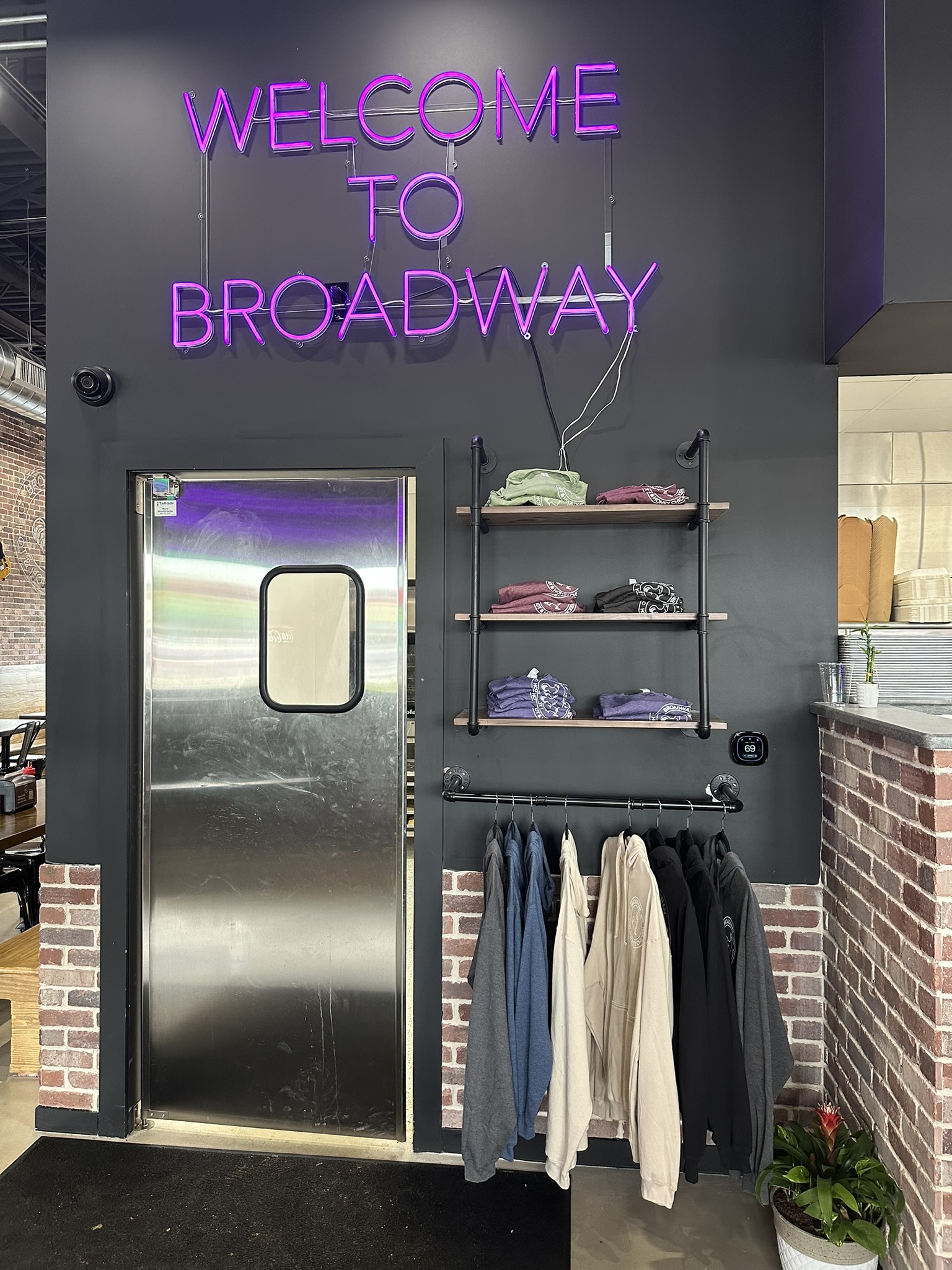 Swinging door with business apparel selection and neon sign decor